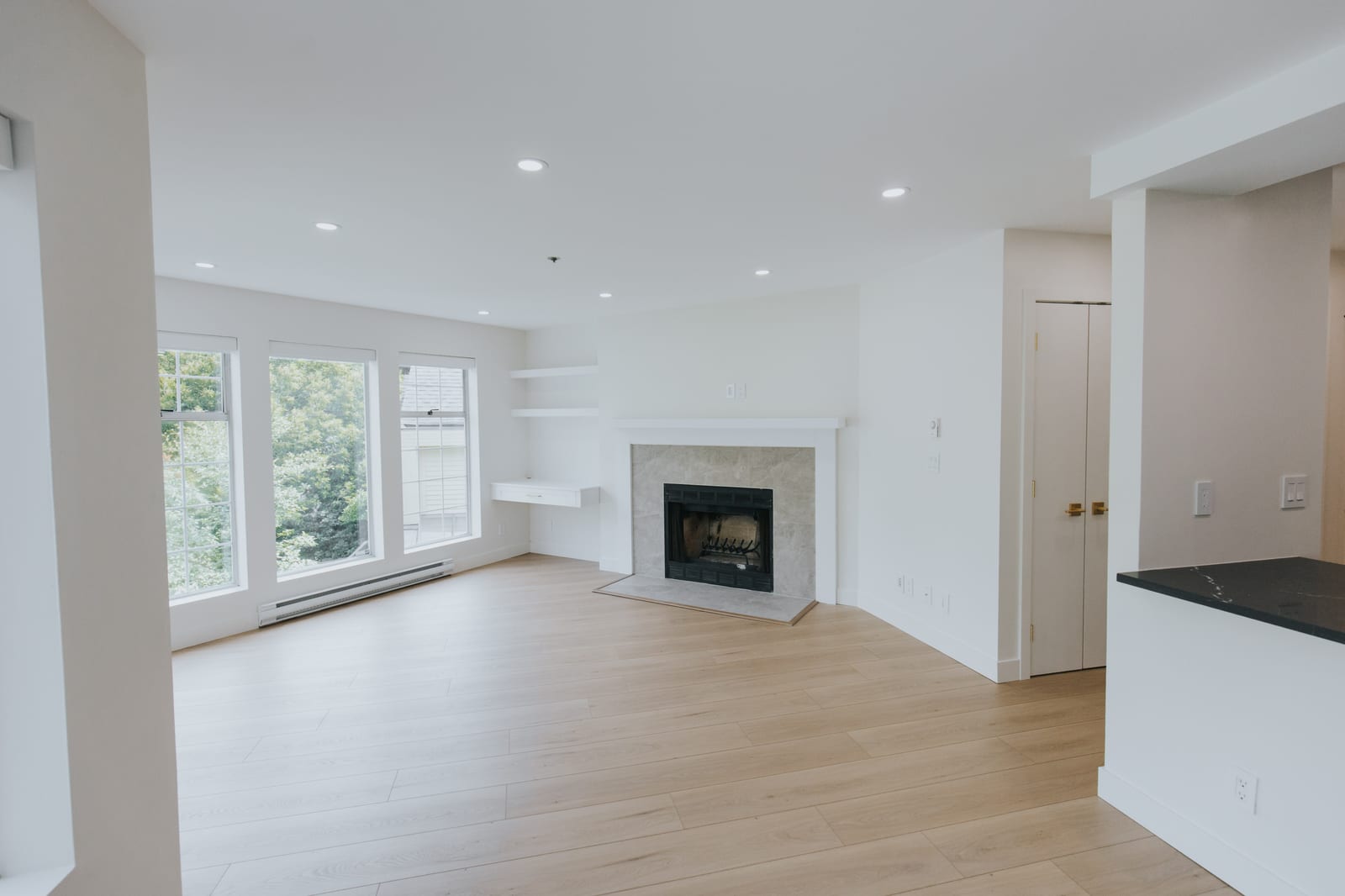 Living room with rebuilt fireplace and custom built-in work-from-home station with floating desk and shelving